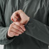 A grey women's full zip rain jacket with a close-up of the cuff detail on the sleeve. It features a logo.