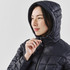 A woman wearing a navy puffer jacket with a hood, featuring a zipped front and quilted design.