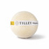 A bath bomb in a round shape, cream-coloured with a yellow label featuring branding.