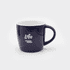 A ceramic mug in navy blue with a white interior and a curved handle, featuring a logo on the side.