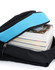 A black backpack with a blue zipper, partially open to reveal several neatly stacked books inside.