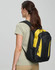 A black and yellow backpack is worn on the back of a person facing away from the camera. The backpack has a logo.