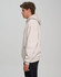 A unisex premium fleece oversized hoodie in light beige, featuring a hood and a front pocket, with a logo visible.