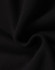 A close-up of black fleece fabric, showcasing its soft texture and smooth finish, with a logo present.