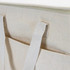 A cream-coloured lunch cooler bag with sturdy handles and a pocket. Features a zip closure and stitching details.
