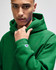 A green hooded sweatshirt with a logo, featuring a relaxed fit and front pocket. Perfect for casual wear.