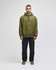 An olive green pullover hooded sweatshirt with a front pocket and a logo, worn with black pants.
