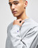 A grey Champion Reverse Weave® adult crew sweatshirt with a logo on the sleeve, modelled by a person.