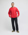 A red adult crew sweatshirt worn by a model, paired with black pants and green sneakers. The sweatshirt has a logo.