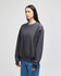 A grey adult crew sweatshirt with a relaxed fit and branding detail on the sleeve, paired with blue jeans.