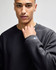 A dark grey sweatshirt with a crew neckline and a small logo on the sleeve.