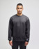 A grey adult crewneck sweatshirt featuring a logo, modelled by a person standing straight.