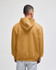 A hooded sweatshirt in a warm mustard colour, featuring a kangaroo pocket and a logo on the back.