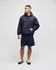 A navy pullover hooded sweatshirt with a pocket, worn by a model standing in shorts.