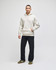 A light grey pullover hooded sweatshirt worn by a model, paired with dark trousers and shoes. The sweatshirt has a logo.