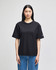 A black Champion Adult Heritage Jersey T-Shirt displayed on a model, featuring a logo on the sleeve.