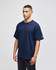 A navy blue Champion Adult Heritage Jersey T-Shirt displayed on a model. The shirt features a logo on the sleeve.