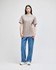 A light brown short-sleeve t-shirt displayed on a model, paired with blue jeans and white sneakers. The shirt has a logo.