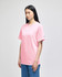A pink Champion adult short-sleeve T-shirt, displayed on a model standing in profile.