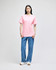 A model wearing a pink Champion short-sleeve t-shirt paired with blue jeans. The shirt features a logo.
