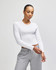 A fitted white long-sleeve cropped T-shirt worn with grey sweatpants, featuring a logo on the shirt.