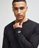 A black long-sleeve t-shirt featuring a logo on the sleeve, worn by a young male model.