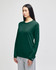 A long-sleeve t-shirt in dark green, featuring a logo on the sleeve, displayed on a model.