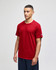 A red Champion adult jersey short sleeve T-shirt displayed on a model, featuring a logo on the sleeve.