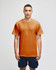 An orange short sleeve T-shirt with a logo, modelled by a person wearing navy shorts.