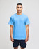 A blue short sleeve t-shirt on a model, featuring a logo on one sleeve. The model is wearing navy shorts.