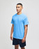 A light blue short sleeve T-shirt on a model, paired with dark shorts, featuring a logo on the sleeve.