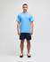 A light blue Champion adult jersey short sleeve t-shirt, worn by a man with navy shorts and brown shoes.
