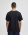 A black Champion adult jersey short sleeve t-shirt viewed from the back. The model is standing against a plain background.