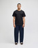 A black short sleeve T-shirt worn with navy blue pants, featuring a logo on the T-shirt.