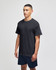 A model wearing a black short sleeve t-shirt with a logo, paired with navy shorts.
