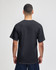 A black short sleeve t-shirt featuring a plain design and back view of a model. It has a logo featured.