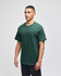 A green Champion Adult Jersey Short Sleeve T-Shirt displayed on a model, featuring a small logo on the sleeve.