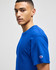 A blue Champion adult jersey short sleeve t-shirt, featuring a logo on the sleeve and a model in profile.