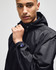 A man wearing a black Champion adult full-zip anorak jacket with a logo on the sleeve.