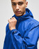 A blue full-zip anorak jacket with a hood, featuring a logo on the sleeve.