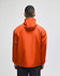 An orange packable anorak jacket with a hood, featuring long sleeves and a logo. View from the back.