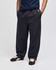 Open-bottom fleece pants in dark grey with pockets, styled with a navy top and brown shoes, featuring a branding logo.