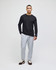 A model wearing a black long-sleeve top and light grey fleece jogger pants, featuring a logo on the joggers.