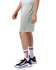 Light green mesh shorts with pockets, featuring a logo, displayed on a model wearing sporty shoes and socks.