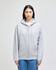 A grey full-zip hooded sweatshirt with a hood and a logo on the sleeve, styled on a model.