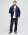 A man wearing a navy full-zip hooded sweatshirt paired with a white T-shirt and black pants.