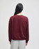 A maroon women's crewneck sweatshirt with a relaxed fit, featuring a branded logo on the back.