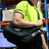 A black duffel bag and drink bottle held by a person in a high-visibility yellow shirt, with a logo visible.