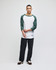 A raglan baseball T-shirt in white with green sleeves, paired with black pants. It features a logo on the hem.