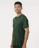 A man wearing a green performance t-shirt, featuring a fitted design and short sleeves. The shirt has a logo.